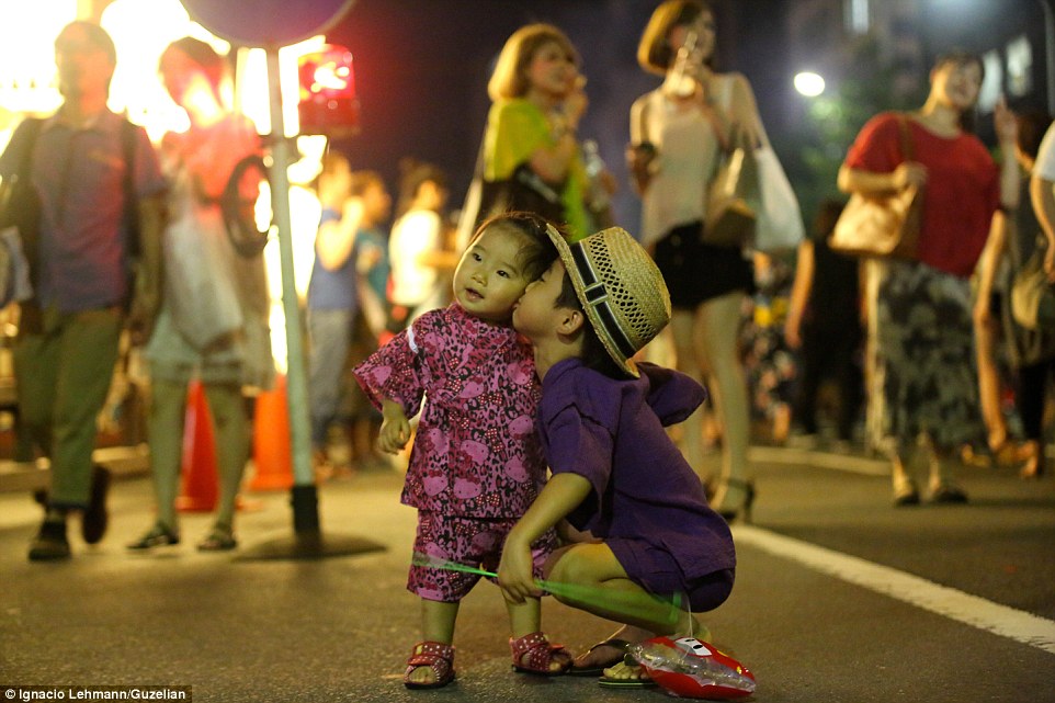 Um garotinho em Kyoto no Japão, se inclina para dar um beijo na bochecha de sua irmã mais nova. Foto: Ignacio Lehmann.