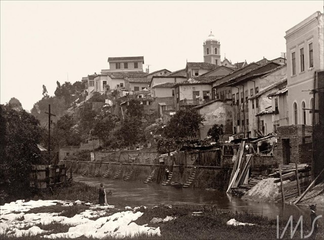 Casario e lavadeira às margens do rio Tamanduateí. Foto: Vincenzo Pastore / Acervo IMS.