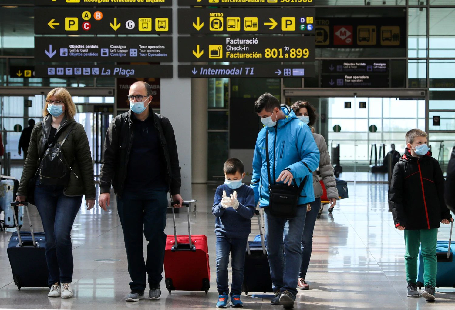 Pais e crianças usam máscaras de proteção no aeroporto de Barcelona. Foto: Nacho Douce / Reuters. 
