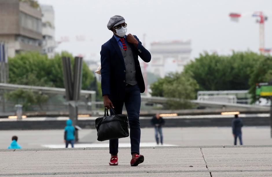 Um homem usando uma máscara protetora caminha em Paris, no momento em que a França dá início ao fim gradual do isolamento nacional por conta do coronavírus. Foto: Gonzalo Fuentes / Reuters.